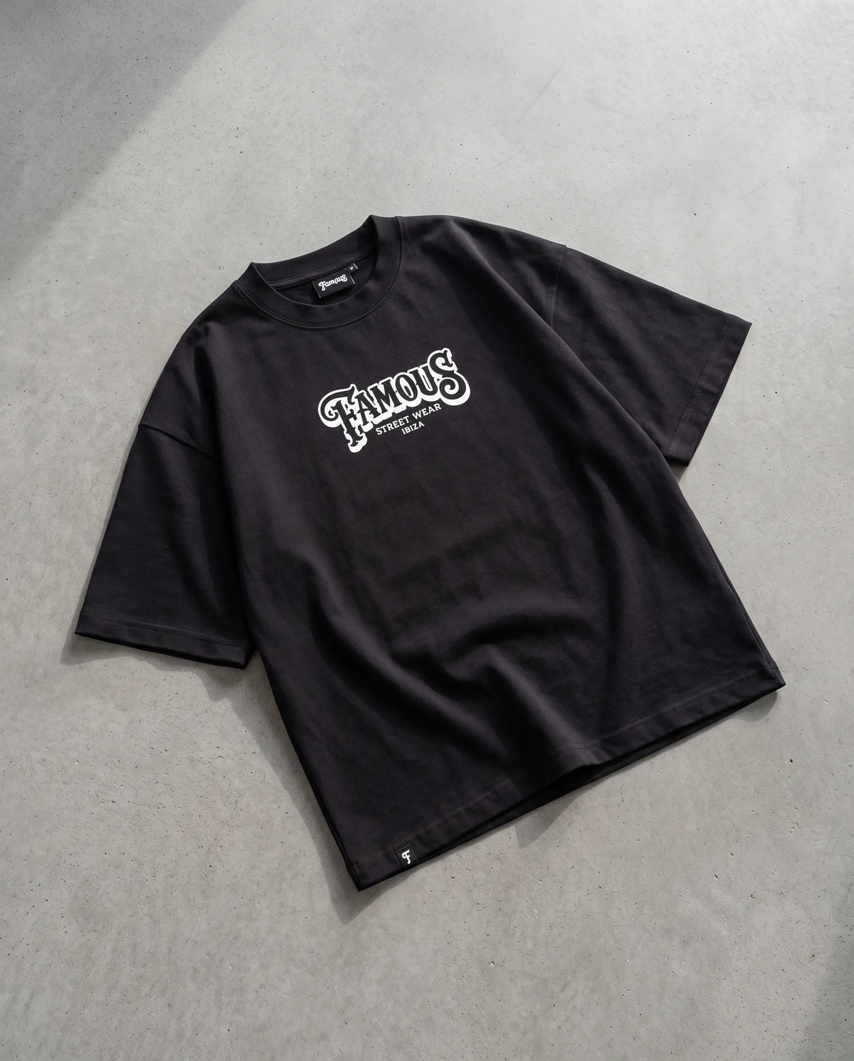 Camiseta Famous Streetwear sobre hormigón